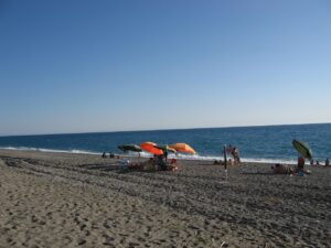 Spiaggia nera di Maratea con acque cristalline e scogliere, un contrasto di colori mozzafiato in Basilicata.